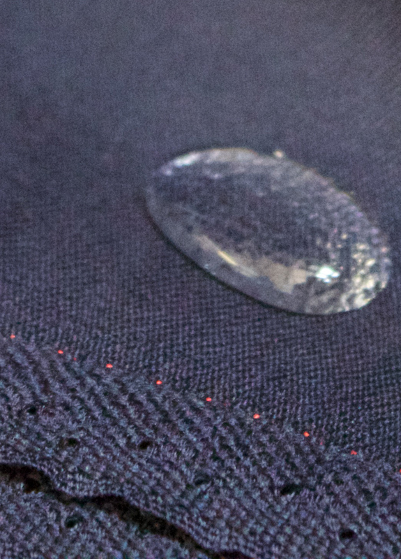 Close-up of a water droplet beading on navy cloth